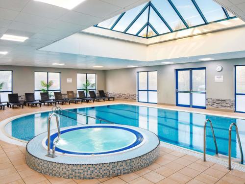 a large pool with a hot tub in a hotel room at Mercure Birmingham West Hotel in West Bromwich