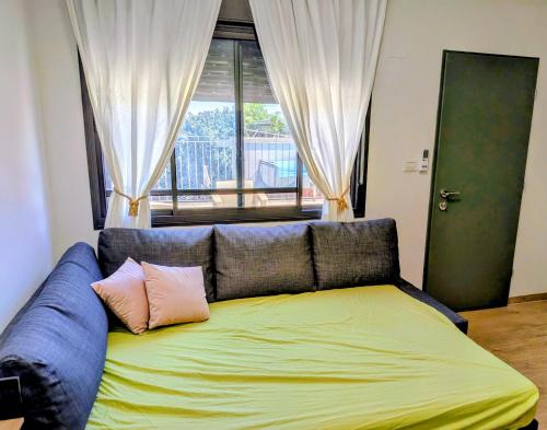 a couch with two pillows on it in a room at Noy Hosting in the Golan in Nov