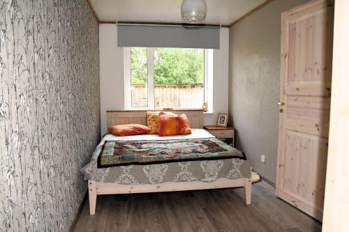 a small bedroom with a bed and a window at Voore Korterid in Ohukotsu