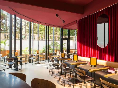 un restaurant avec des murs rouges, des tables et des chaises dans l'établissement ibis Brussels Centre Chatelain, à Bruxelles