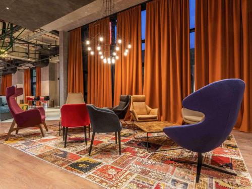 a living room with chairs and a chandelier at ibis Tbilisi Stadium in Tbilisi City