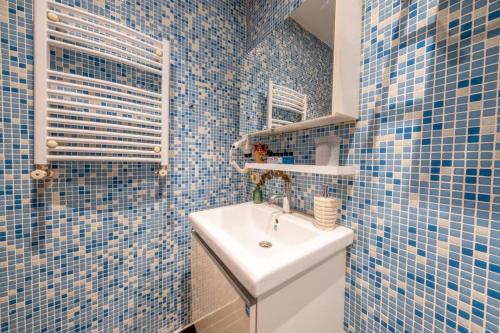 a bathroom with blue tiled walls and a sink at The King Suit Beşiktaş in Istanbul