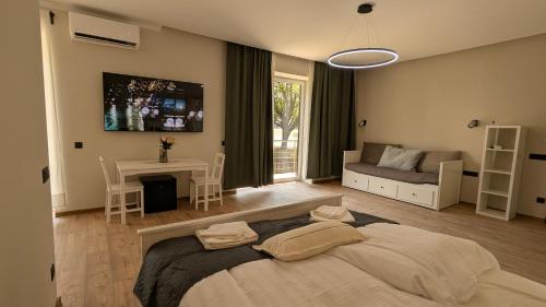 a bedroom with a large bed and a living room at Apartmány Villa Vician in Piešťany