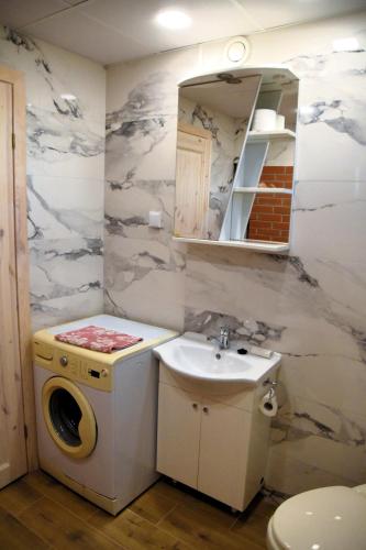 a bathroom with a sink and a washing machine at Voore Korterid in Ohukotsu