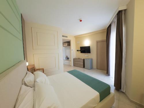 a hotel room with a bed and a television at Oro Hotel in Policoro