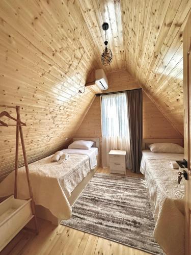 a attic room with two beds and a window at Kaniore Cottage in Martvili