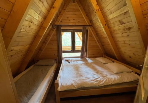 an attic bedroom with a bed and a window at Villa Albani in Peje