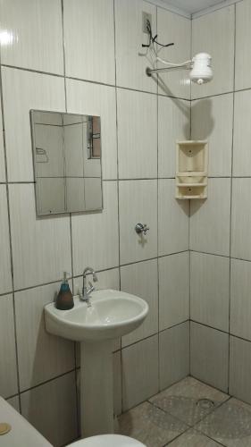 a white bathroom with a sink and a mirror at Casa cantinho da Rubi in Atibaia