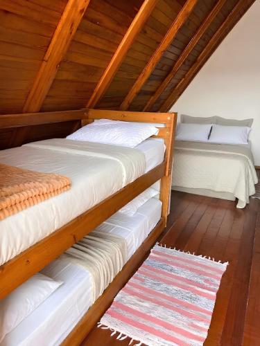 two bunk beds in a room with wooden floors at Pousada Canto Gira Sol Estúdio Beija Flor 2º Andar 5 Min do Beto Carrero Penha SC in Penha