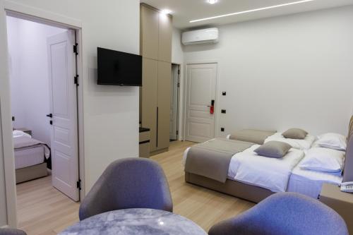 a bedroom with two beds and two chairs and a television at Lchak Hotel in Yeghegnadzor