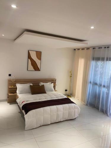a bedroom with a large bed in a room at Elegance appart-Yoff virage in Dakar