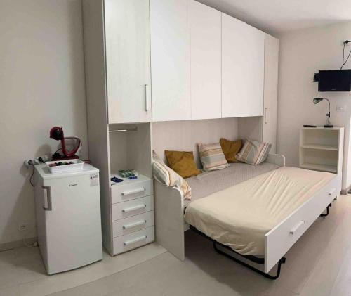 a small bedroom with a bed and white cabinets at Studio apartment on the lake in Lovere