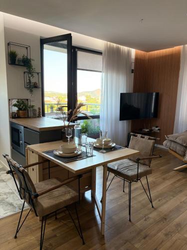 a living room with a table and chairs and a television at River view Kardzhali in Kŭrdzhali