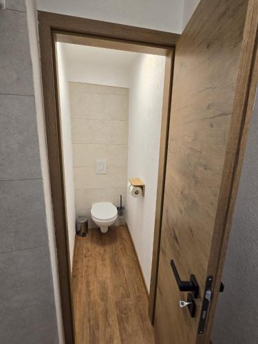 a door to a bathroom with a toilet in it at Ludo Rooms in Radlje ob Dravi