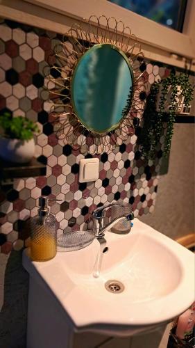a bathroom sink with a mirror on a tiled wall at DAGNA summer house in Šunupis