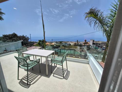 a table and chairs on a balcony with a view of the ocean at Gándara Lodge Luxury in Tijoco de Abajo