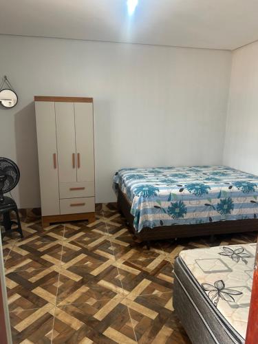 a bedroom with two beds and a dresser in it at Kit net individual in Araguaína