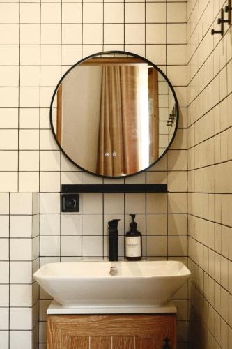 a bathroom with a sink and a mirror at Racha Roots Boutique House in Ambrolauri