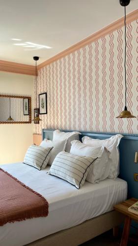 a bedroom with a bed with white pillows at Hotel Saint-Enogat in Dinard