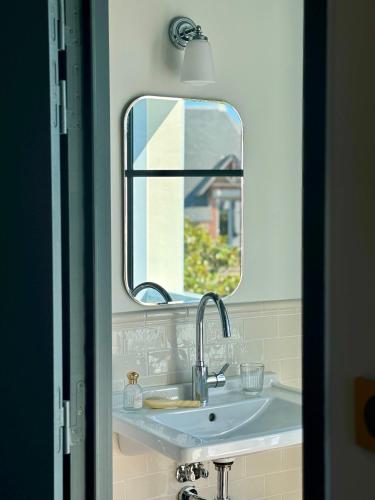 a bathroom with a sink and a mirror at Hotel Saint-Enogat in Dinard