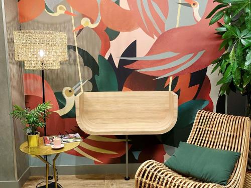 a room with two chairs and a colorful wall at ibis Styles Rennes Cesson in Cesson-Sévigné