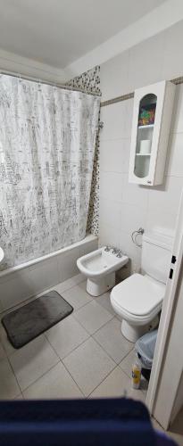 a bathroom with a toilet and a tub and a sink at Nuestra Recova en Pilar BsAs in Pilar