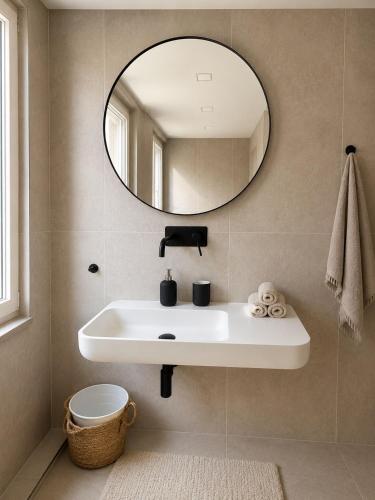 a bathroom with a white sink and a mirror at Altstadt-Loft Würzburg in Würzburg