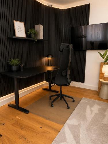an office with a black desk and a chair at Altstadt-Loft Würzburg in Würzburg