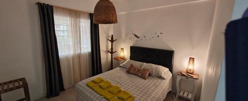 a bedroom with a bed with yellow pillows and a window at Nuestra Recova en Pilar BsAs in Pilar