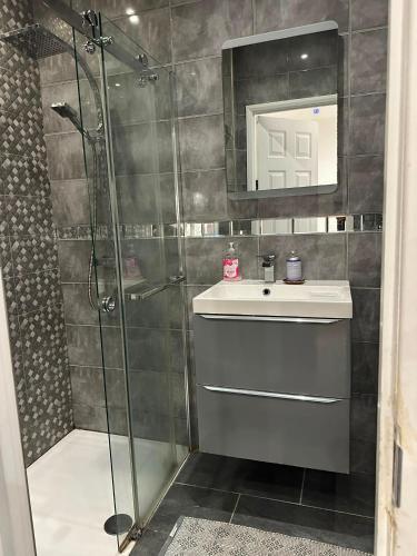 a bathroom with a shower and a sink and a mirror at Holiday Plus - 50 Palatine Road in Blackpool