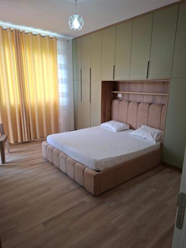 a bedroom with a large bed with a headboard at Rafaelo Apartament in Lezhë