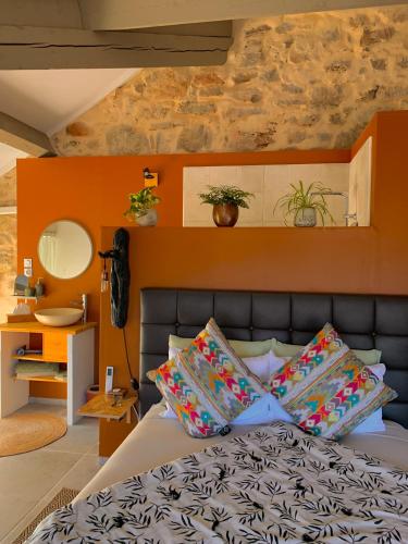 a bedroom with a bed with an orange wall at Moulin Lombard B&B Chambre et table d Hôtes Massages & Bien-être in Les Arcs sur Argens