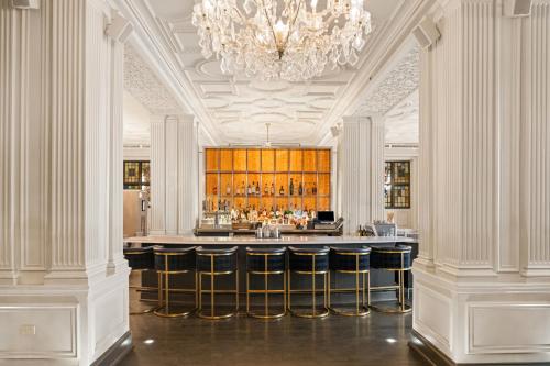 a bar in a building with a chandelier at Magnolia Hotel St. Louis, a Tribute Portfolio Hotel in Saint Louis