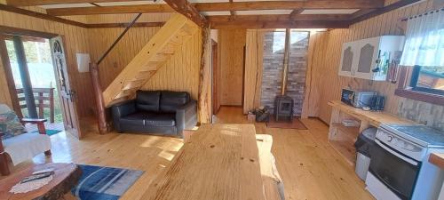 a room with a couch and a table in a cabin at Cabañas Llifén Costanera in llifen
