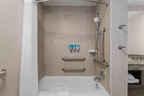 a bathroom with a tub and a shower at Drury Plaza Hotel Mobile in Mobile