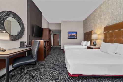 a hotel room with a bed and a desk at Drury Plaza Hotel Mobile in Mobile
