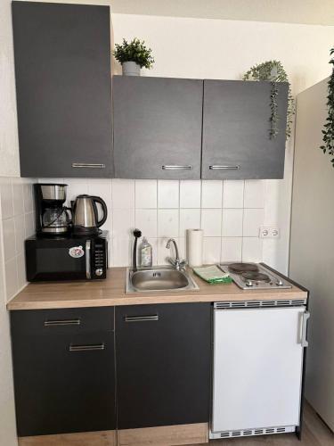 a kitchen with a sink and a microwave at Modern Apartment Close to Bus Station in Würzburg