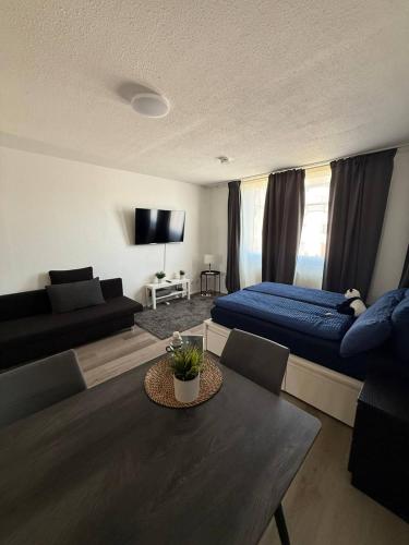 a living room with a couch and a bed and a table at Modern Apartment Close to Bus Station in Würzburg