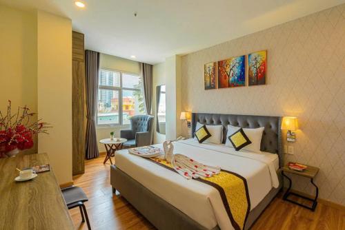 a hotel room with a large bed and a chair at Happy Life Hotel District 7 Gần SECC in Ho Chi Minh City