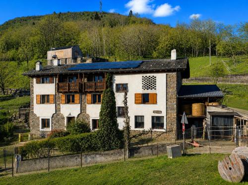 a large white house with a hill in the background at Ca' Bastiàn in Sacco