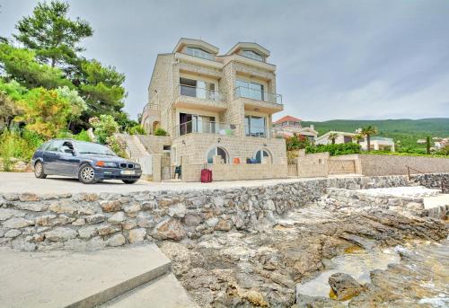 a car parked in front of a large house at Leut Apartments in Tivat