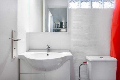 Un baño blanco con lavabo e inodoro. en Nouvel Oasis Toulouse Saint Cyprien, en Toulouse