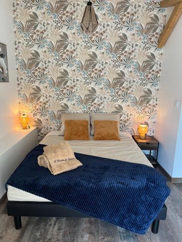 a bedroom with a bed with a blue blanket at L'Escale de Gaston in Sainte-Florence