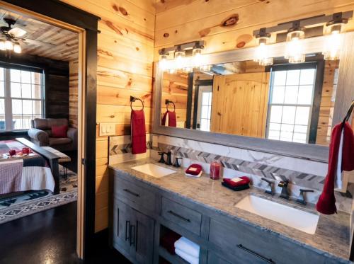 a bathroom with two sinks and a large mirror at Luxury 6 BED 5 BATH Mountain Cabin HOT TUB Theater Sleeps 20 IDEAL LOCATION Fireplace KING SUITES Fire Pit GAME ROOM in Sevierville