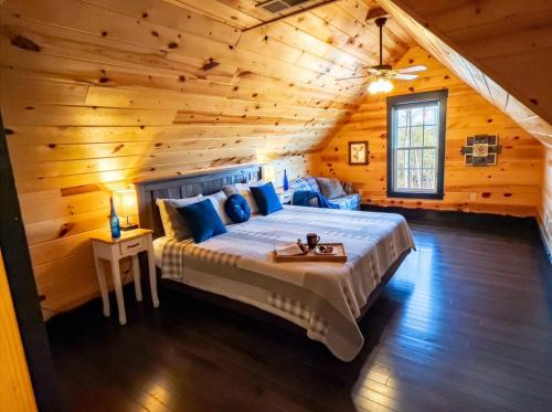 a bedroom with a bed in a log cabin at Luxury 6 BED 5 BATH Mountain Cabin HOT TUB Theater Sleeps 20 IDEAL LOCATION Fireplace KING SUITES Fire Pit GAME ROOM in Sevierville