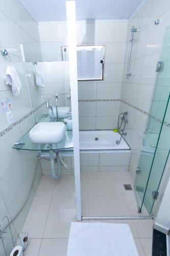 a white bathroom with a sink and a shower at Casa do Henrique 2 in Sorocaba
