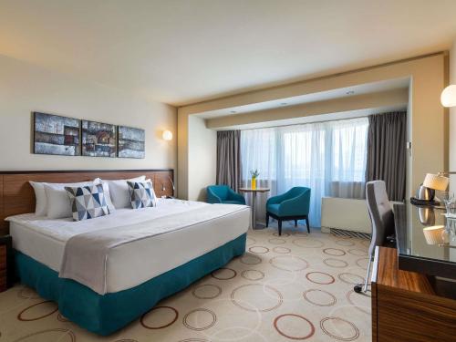 a hotel room with a large bed and a desk at Handwritten Collection-Bucharest Unirii Square in Bucharest