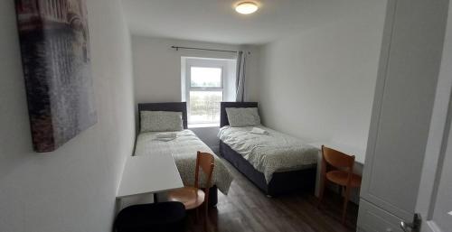 a small room with two beds and a table at High Tide House in Waterford