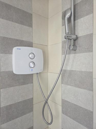 a shower head with a hose attached to a wall at High Tide House in Waterford