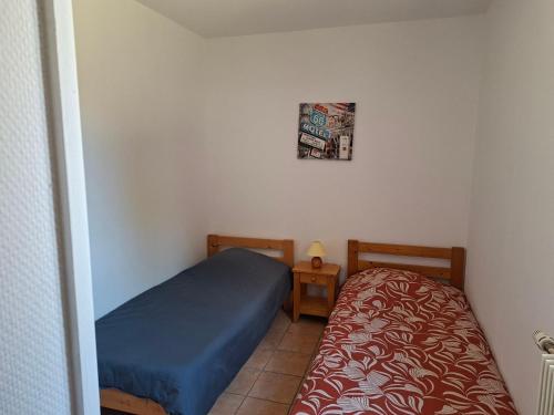 a small bedroom with a bed and a table at Gîtes proche lac de chalain in Montigny-sur-lʼAin